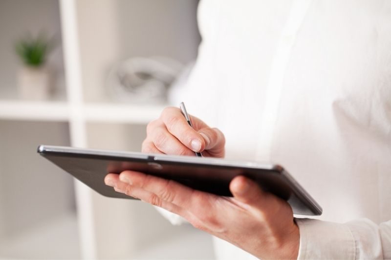 hombre con tablet y camisa blanca
